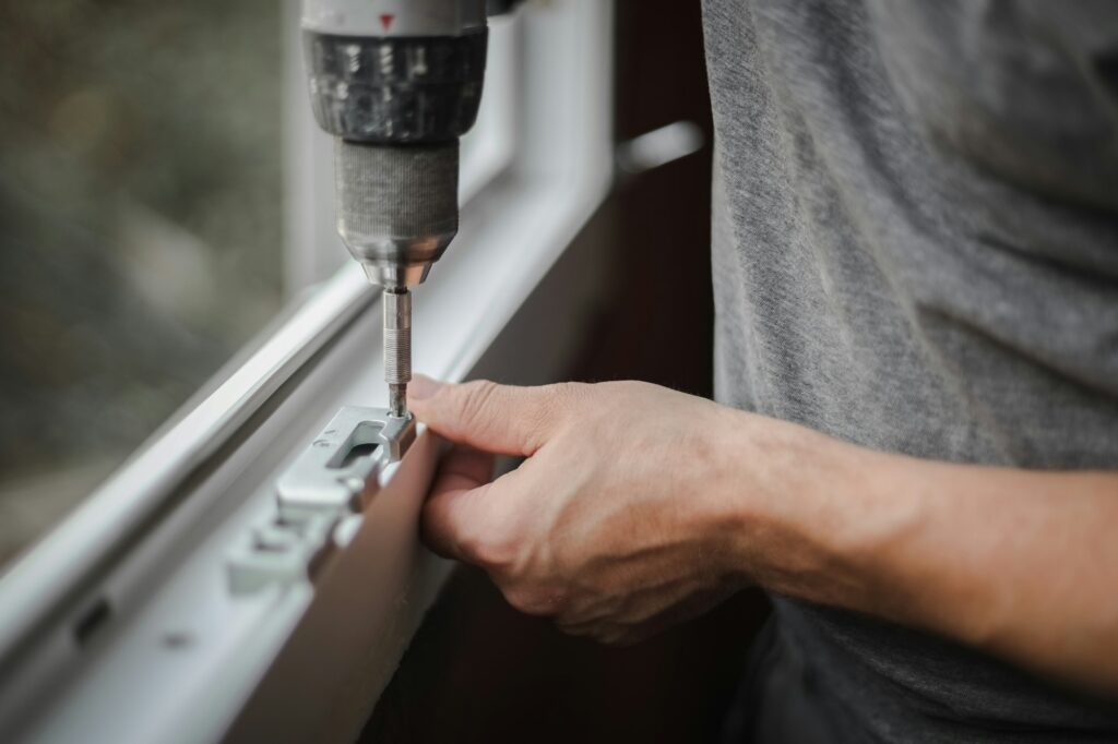 Caucasian man installs fittings for a window frame.